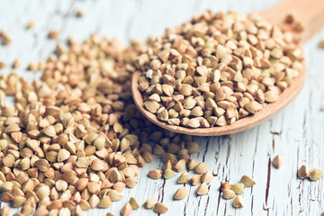 uncooked buckwheat on wooden spoon