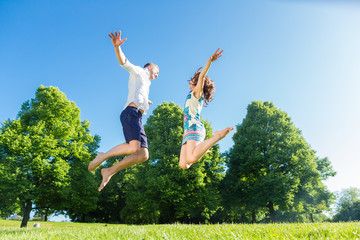 Paar springt verliebt auf Park Wiese