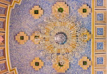 A chandelier from bottom view with colorful ceiling as backgroun