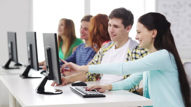 smiling students working with computers at school