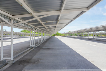Empty car parking lot or garage. Construction building consist of steel structure, roof sheet and concrete pavement floor at outdoor. To covered for shade and shadow. Modern architecture for city.
