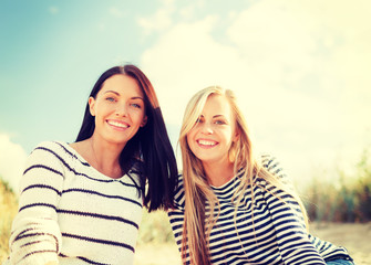 smiling girlfriends having fun on the beach