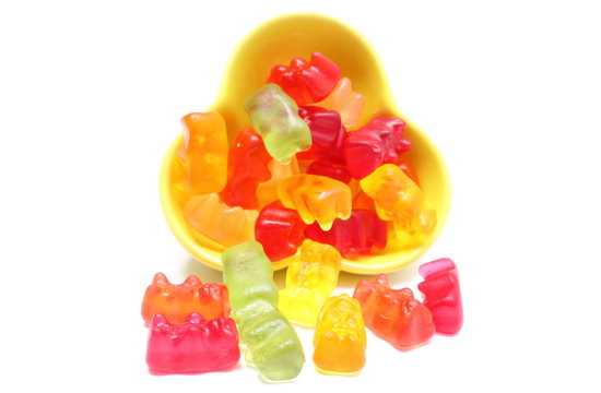 Colorful Haribo Bear Candies Pouring Out Of Yellow Bowl.