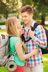 Fototapeta premium smiling couple with backpacks in nature