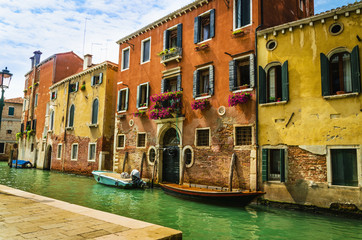 Venetian canal with old colorful brick houses in Venice, Italy.