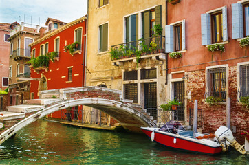 Fototapeta na wymiar Scenic canal with boat and bridge, Venice, Italy