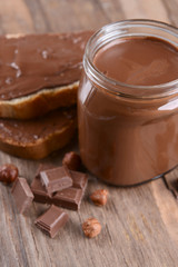 Sweet chocolate cream in jar on table close-up