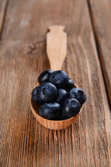 Delicious blueberries in spoon on table close-up