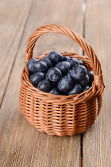 Fototapeta na wymiar Delicious blueberries in wicker basket on table close-up