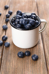 Delicious blueberries in cup on table close-up