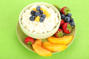 Cottage cheese with fruits and berries in bowl on table