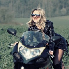 Fototapeta na wymiar beautiful blonde woman on a sports motorcycle. Urban life style.