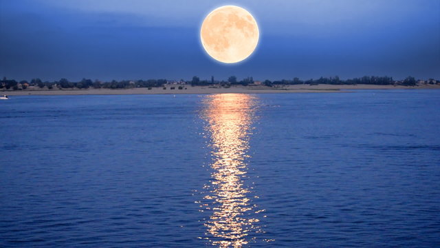 Supermoon rising over river