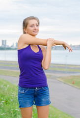Young woman stretches before doing sports.