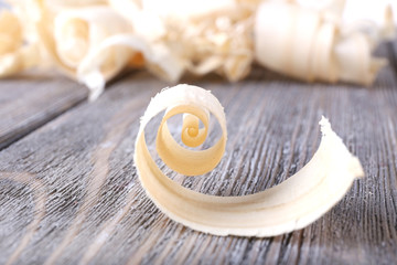 Wood shavings on grey wooden background closeup