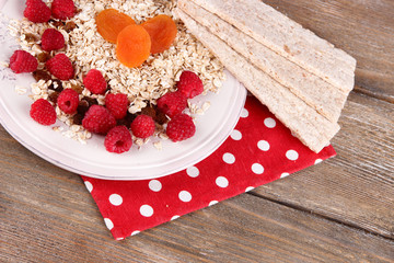 Big plate with oatmeal, small loaves of bread and berries