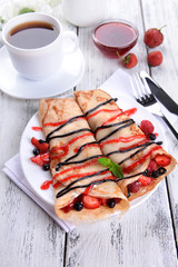 Delicious pancakes with berries on table close-up