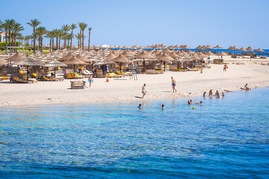 Fototapeta Sun loungers with umbrellas on a beach