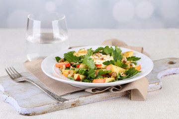 Green salad with apples, walnuts and cheese on light background