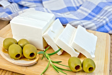Feta with olives and rosemary on board with blue cloth