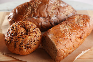 Fresh baked bread, on cutting board, on wooden background