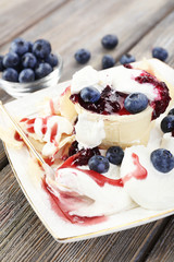 Tasty dessert with fresh blueberries on wooden table