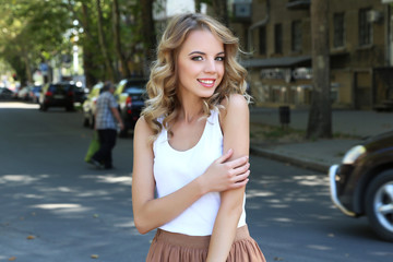 Fototapeta na wymiar Beautiful young girl posing on city street
