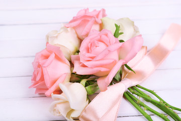 beautiful roses on white wooden background