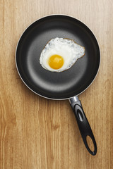 Fried eggs. Pan with handle on wood background