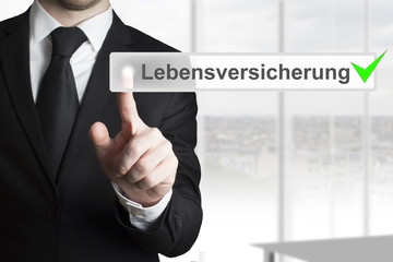 Mann drückt Knopf Lebensversicherung checked