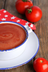 Tasty tomato soup and vegetables on wooden table