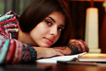 Attractive woman lying on the table with notebook at home
