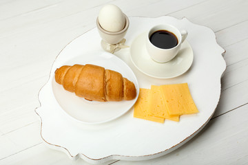 Delicious breakfast with coffee, fresh croissant, egg and