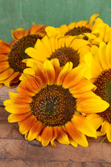 Beautiful sunflowers on table on wooden background