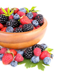 Ripe sweet different berries in wooden bowl, isolated on white