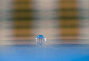 water drop over blue surface at striped background