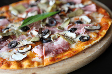 Pizza with dry cured ham and basil