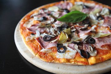 Pizza with dry cured ham and basil