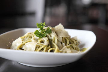 spaghetti with pesto sauce on wood background