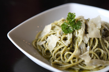 spaghetti with pesto sauce on wood background