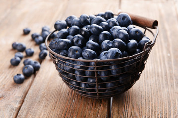Delicious blueberries in wicker basket on table close-up