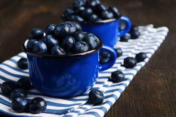 Delicious blueberries in cups on table close-up
