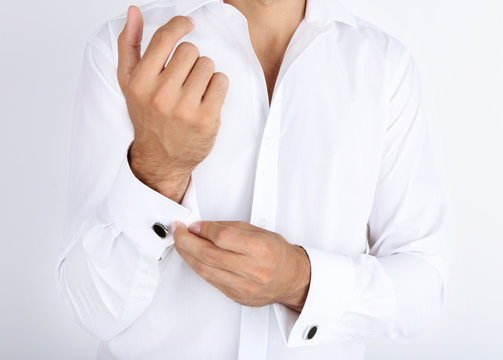 Man in white shirt doing collar button up isolated on white