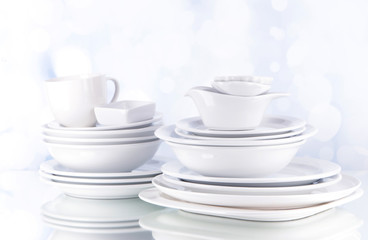 White crockery and kitchen utensils, on light background