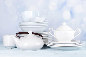 White crockery and kitchen utensils, on light background