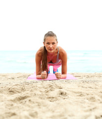 cheerful girl working out on the beach. fitness instructor makin