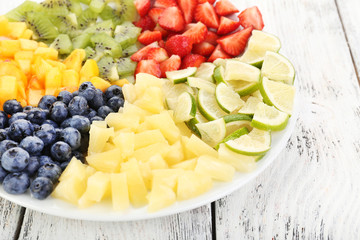 Sliced fruits on plate on wooden table
