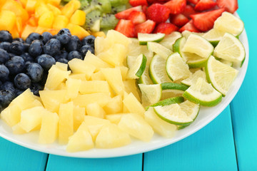 Sliced fruits on plate on wooden table