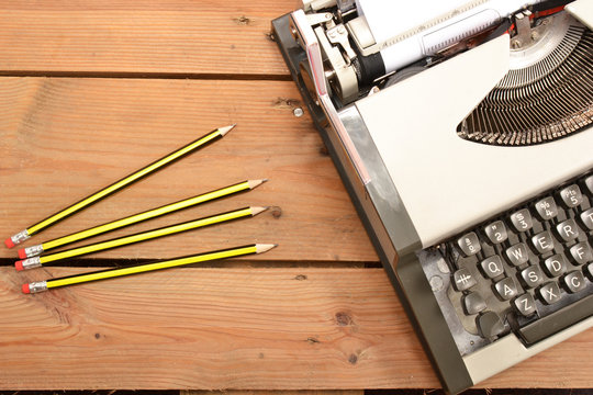 Typewriter, notebook and pencils