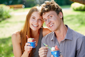 Young couple with a cup of ice cream in summer